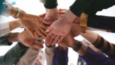 Group of people putting their hands together Group of people putting their hands together