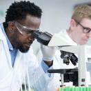 Lab worker looking through microscope Lab worker looking through microscope
