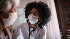 Doctor in mask talking to patient in mask Doctor in mask talking to patient in mask