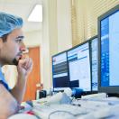 Healthcare worker in scrubs looking at medical image on screen Healthcare worker in scrubs looking at medical image on screen