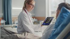 Healthcare worker showing tablet to patient Healthcare worker showing tablet to patient