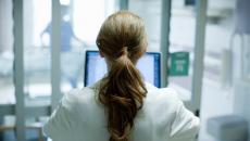 Healthcare working looking at computer screen Healthcare working looking at computer screen