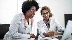 Two health professionals at a laptop Two health professionals at a laptop