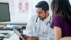 Doctor showing tablet to a patient Doctor showing tablet to a patient