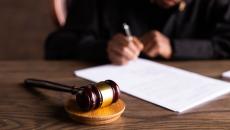 Gavel lies on a table in front of a legal pad Gavel lies on a table in front of a legal pad
