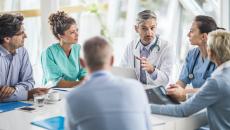 Doctors and payers sit around a table. Doctors and payers sit around a table discussing claims data, prior authorizations and more.