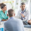 A multidisciplinary team of hospital staff holding a meeting A multidisciplinary team of hospital staff holding a meeting