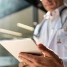 Doctor looking at a patient chart on a digital tablet  Doctor looking at a patient chart on a digital tablet