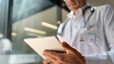 Doctor looking at a patient chart on a digital tablet  Doctor looking at a patient chart on a digital tablet