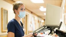 A nurse checking medication records on a laptop A nurse checking medication records on a laptop