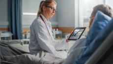 Healthcare worker showing tablet to patient Healthcare worker showing tablet to patient