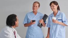 Hospital staff, with one holding the Ascom Myco 4,  in a conversation Hospital staff, with one holding the Ascom Myco 4,  in a conversation