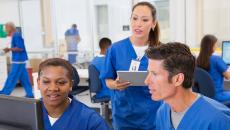 Nurses talking while looking at computer screen Nurses talking while looking at computer screen