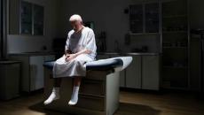 Patient sitting on doctors office bed Patient sitting on doctors office bed