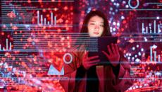 A woman holds up a tablet and data overlays appear all around her. A woman holds up a tablet and data overlays appear all around her.