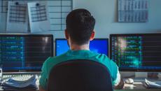 Healthcare worker looking at multiple monitors Healthcare worker looking at multiple monitors