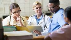 Doctors and nurses discussing a patient's chart from a digital tablet Doctors and nurses discussing a patient's chart from a digital tablet