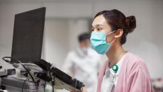 A nurse looking at a laptop dashboard of patient information A nurse looking at a laptop dashboard of patient information