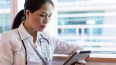 A doctor checking a patient's record on a digital tablet A doctor checking a patient's record on a digital tablet