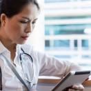 A doctor checking a patient's record on a digital tablet A doctor checking a patient's record on a digital tablet