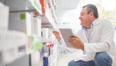 A pharmacist doing an inventory using a digital tablet. A pharmacist doing an inventory using a digital tablet.